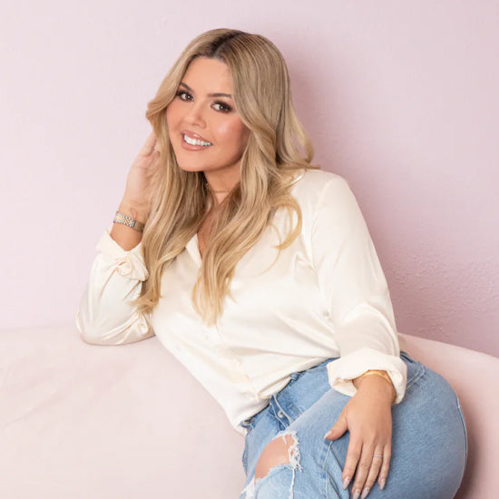 Porträttbild av Kelley Baker som lutar sig tillbaka i en rosa soffa