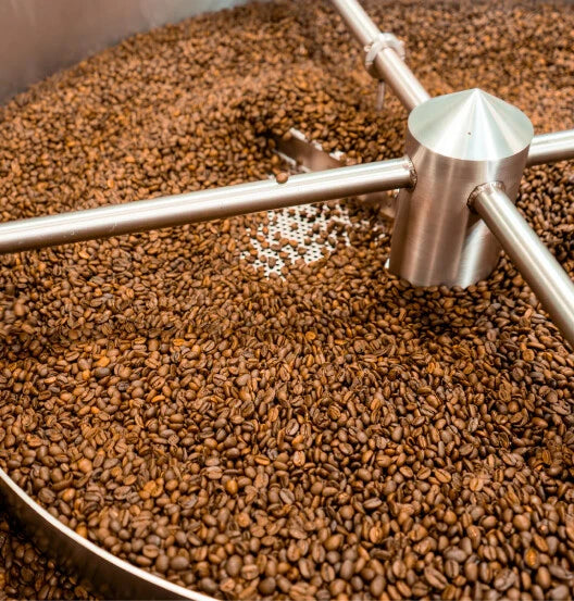 Coffee beans being churned in a machine.