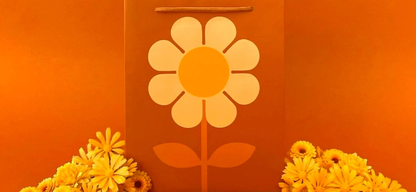 Foto arancione brillante di borse regalo con fiori di Pigment