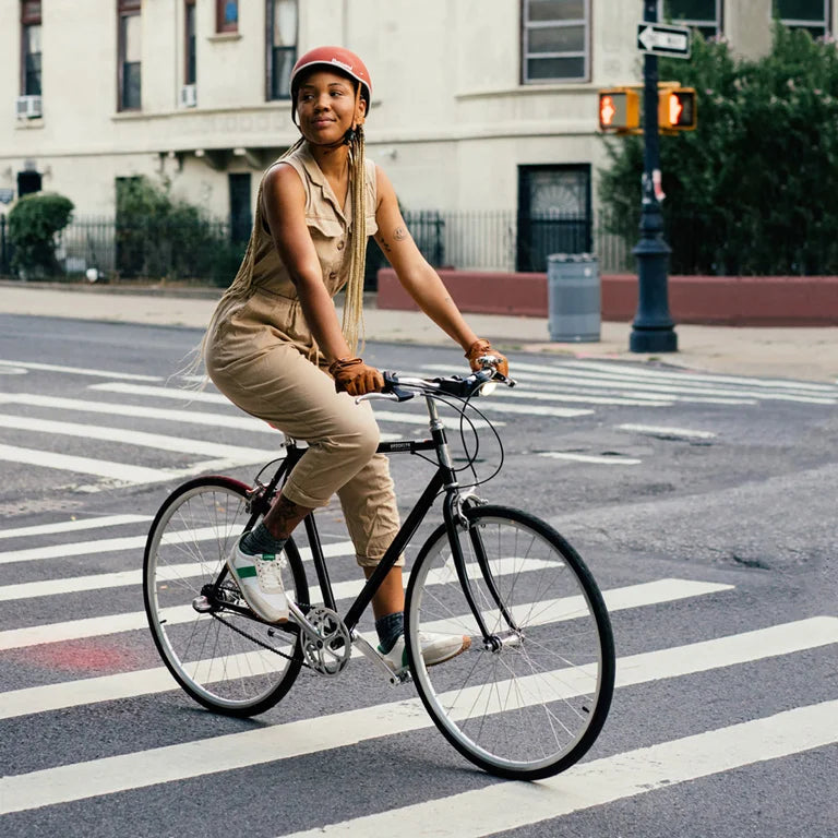 Thousand의 헬멧을 착용하고 도시를 가로지르며 자전거를 타는 사람