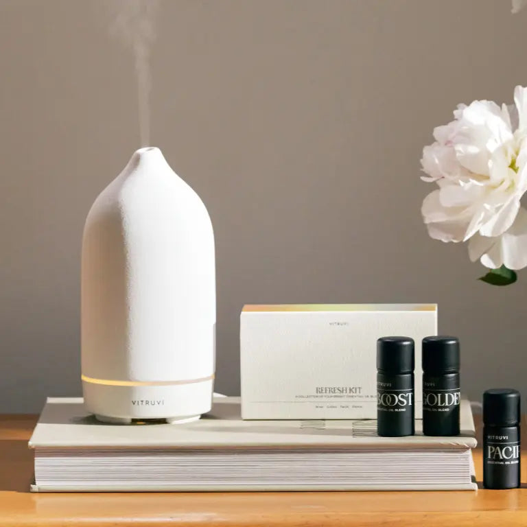 A diffuser on a table with essential oils.